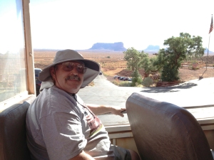 Warren sits in the back of the tour truck with Monument Valley in the background.